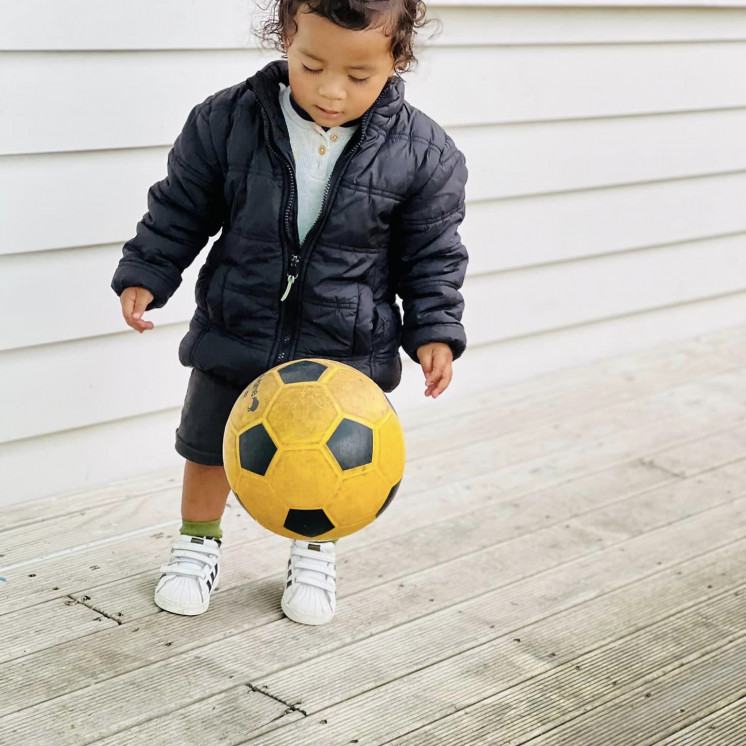 Busy Bees Alfriston Road toddler practicing ball skills during our MOVE physical activity sessions