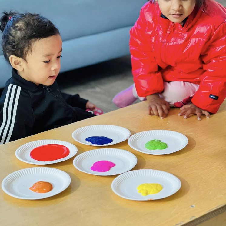Two friends about to explore colour at Busy Bees Alfriston Road
