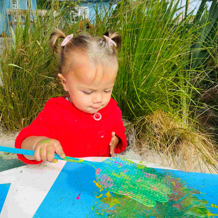 Toddler outside painting at Busy Bees Coopers Beach