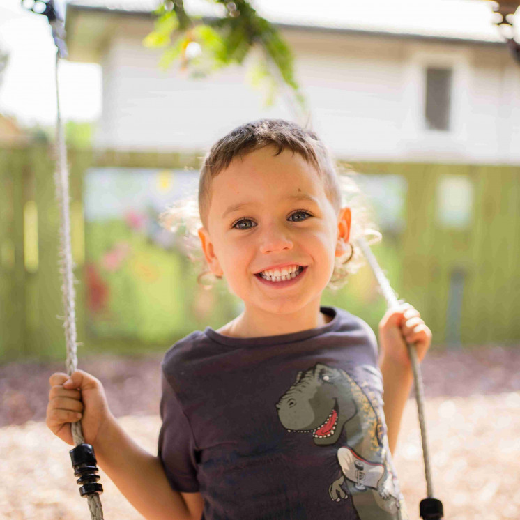 Boy on outdoor swing at Busy Bee Douglas Street