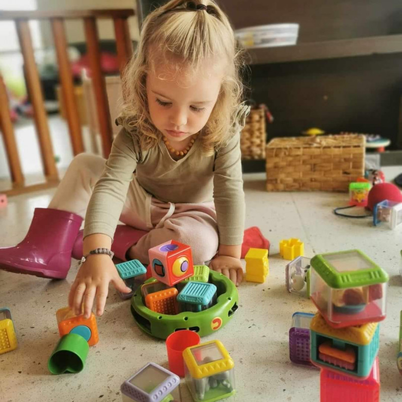 Young child engaged in play stacking blocks at Busy Bees Kawatiri