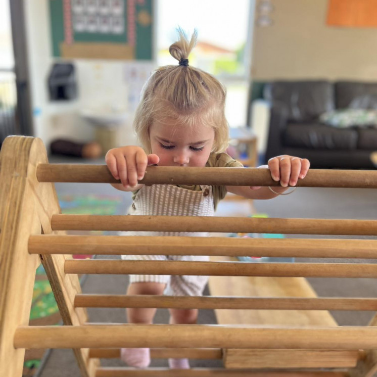 Girl on climbing frame at Busy Bees Kawatiri