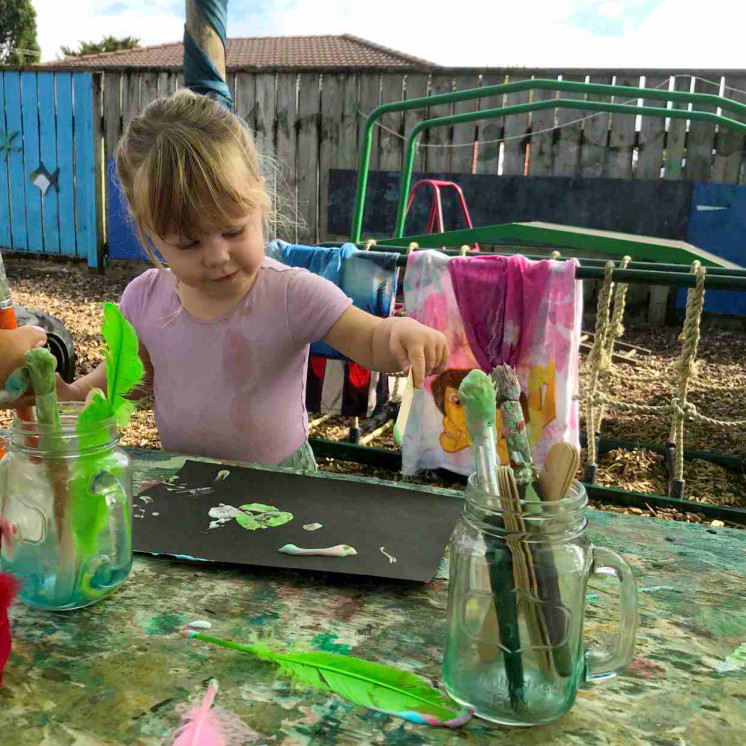Toddler painting at Busy Bees Kerikeri Nursery 