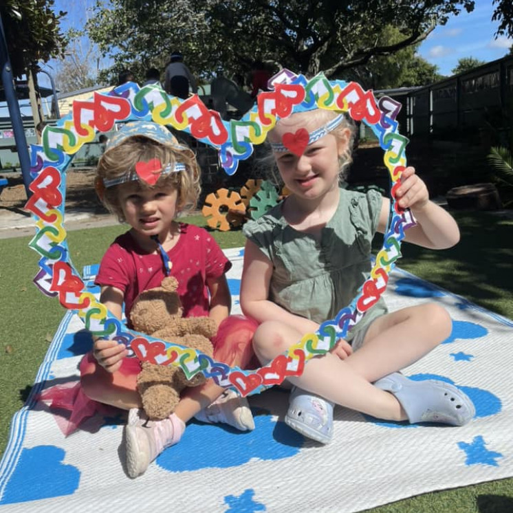 Two friends outside with their heart frame creation at Busy Bees Mount Wellington
