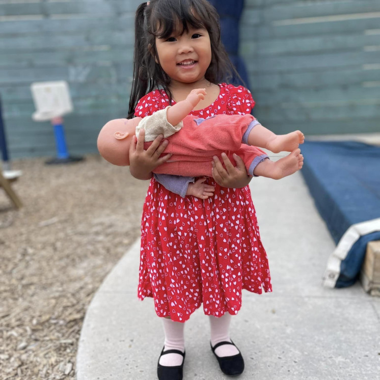 Young girl caring for her doll at Busy Bees Mount Wellington