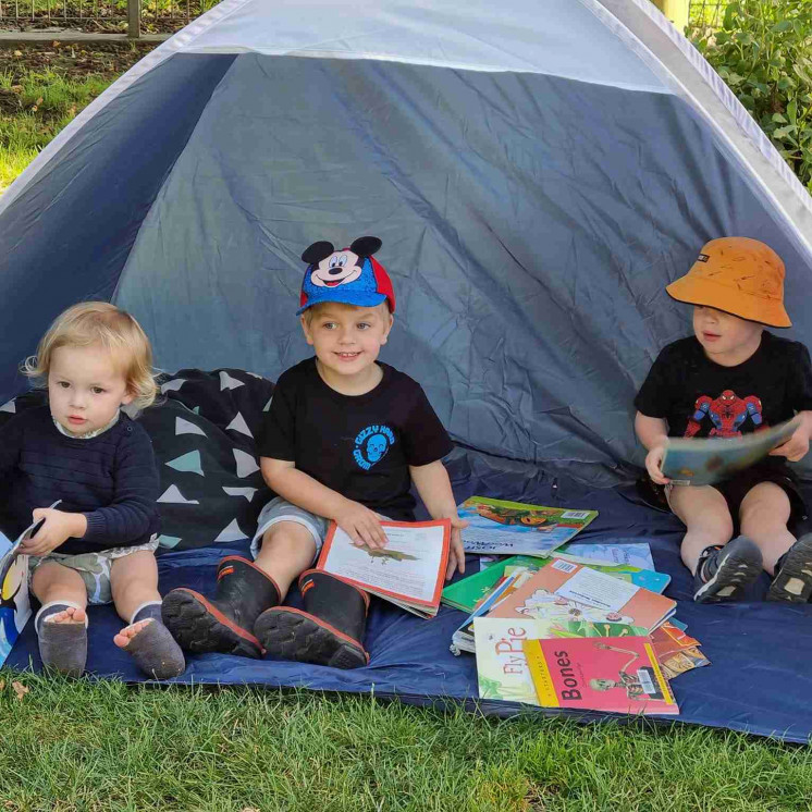 Reading time in a beach shelter at Busy Bees Napier Road