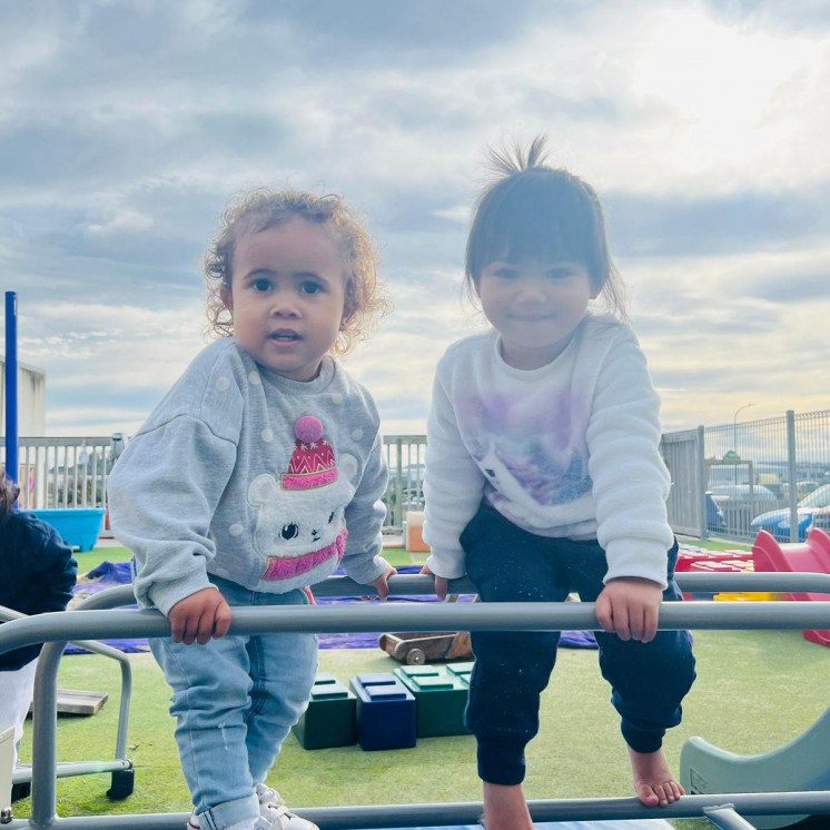 Friends challenging themselves on the climbing frame at Busy Bees Ormiston Road