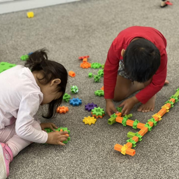 Two friends deep in concentration learning with resources at Busy Bees Ormiston Road