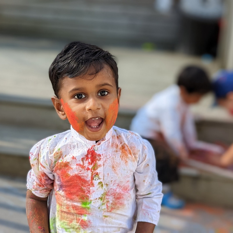 Toddler smiling wide while playing at Busy Bees Otahuhu