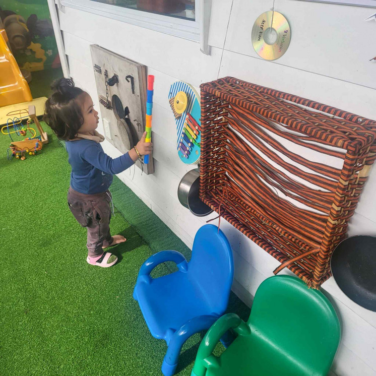 Young child in the nursery room experimenting with the sensory wall Busy Bees Roscommon Road