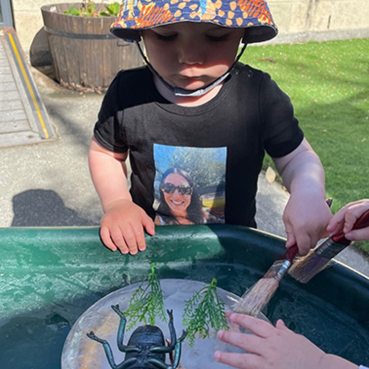 Little boy playing with nature at Busy Bees Southbrook