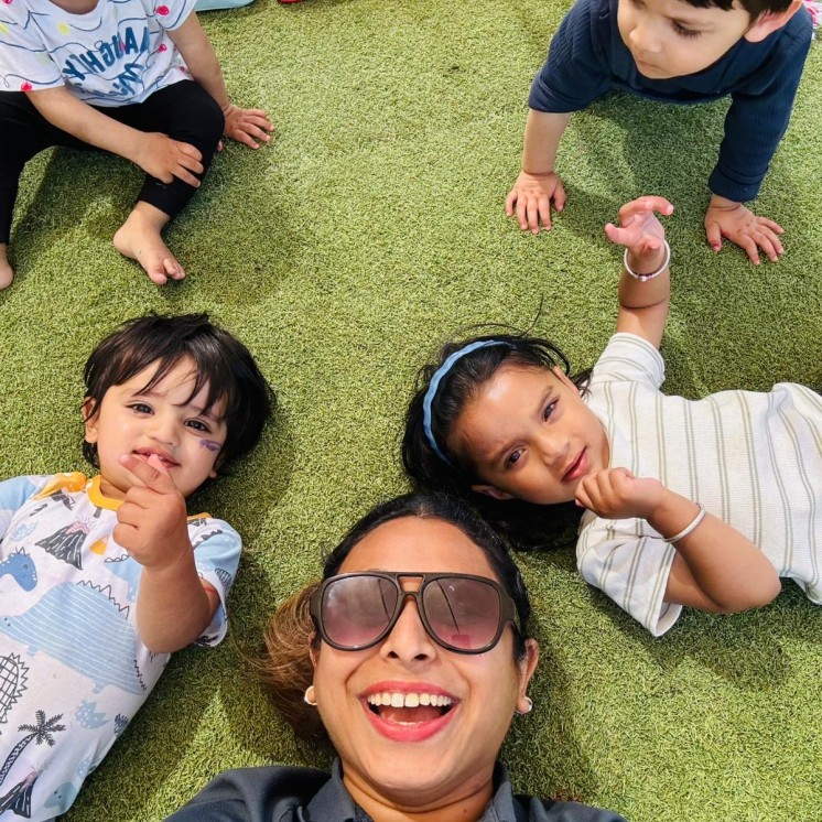 Busy Bees Te Rapa Kids laying on the floor with their teacher with big smiles