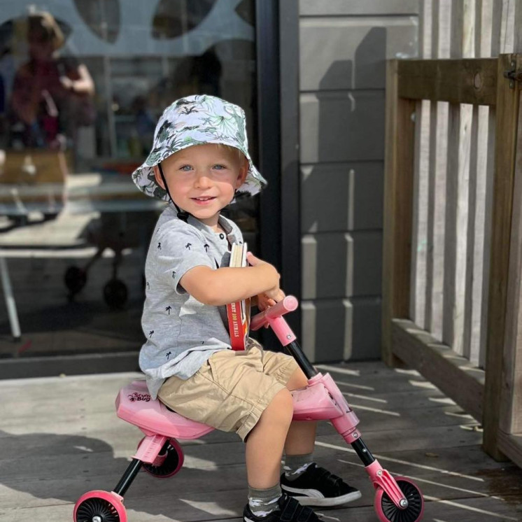 Busy Bees Westgate Boy outside riding bike