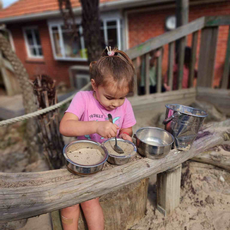 Preschool girl in real world play in the sandpit at Busy Bees Whau Valley 