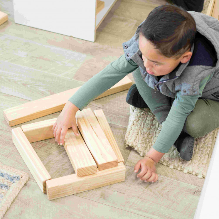 Boy stacking wooden blocks at Busy Bees Tairāwhiti childcare in Gisborne