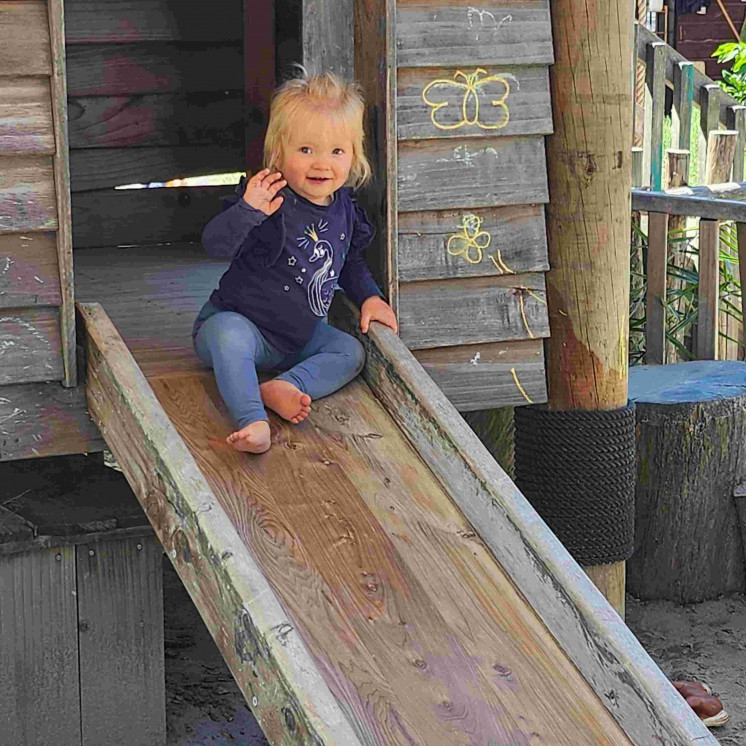Girl sliding down wooden fort at Busy Bees Tairāwhiti childcare in Gisborne